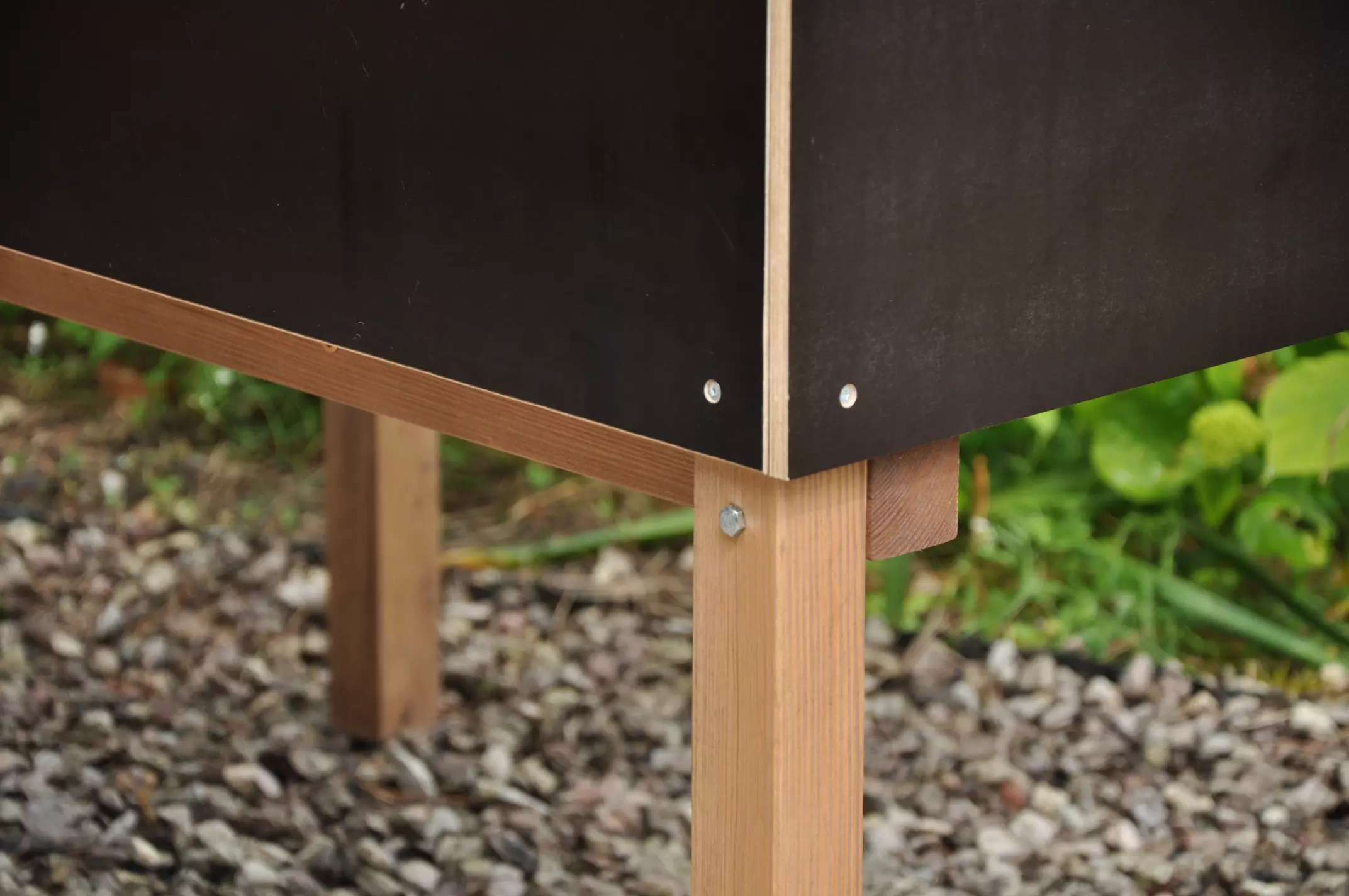 Detail van de onverwoestbare hoekconstructie met stalen bouten en zwart watervast multiplex