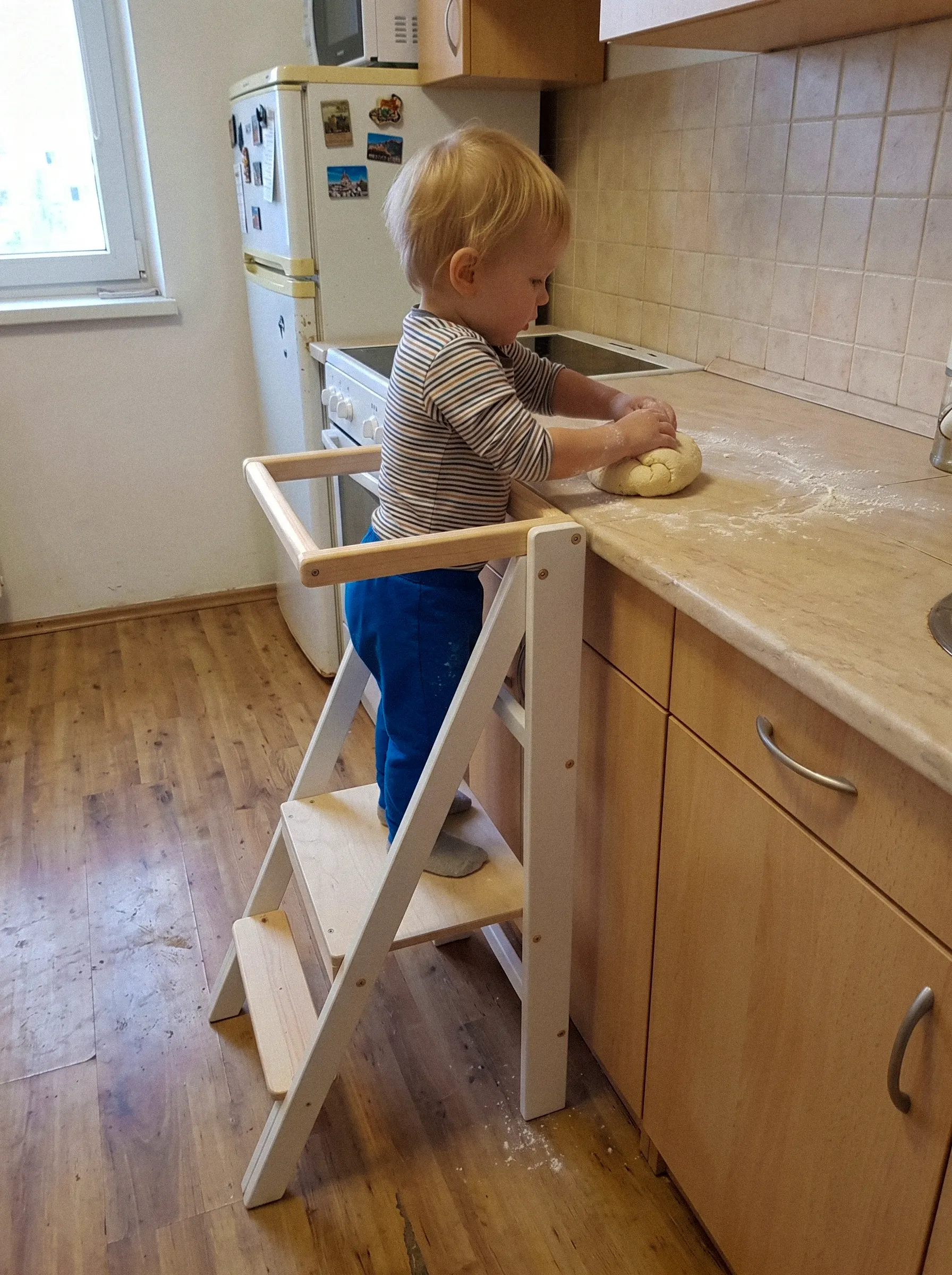 Lapsi käyttää valkoista taitettavaa Barin Toys Slim -oppimistornia keittiössä